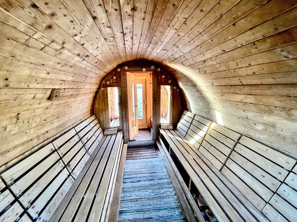 The empty sauna with wooden walls and light from the door