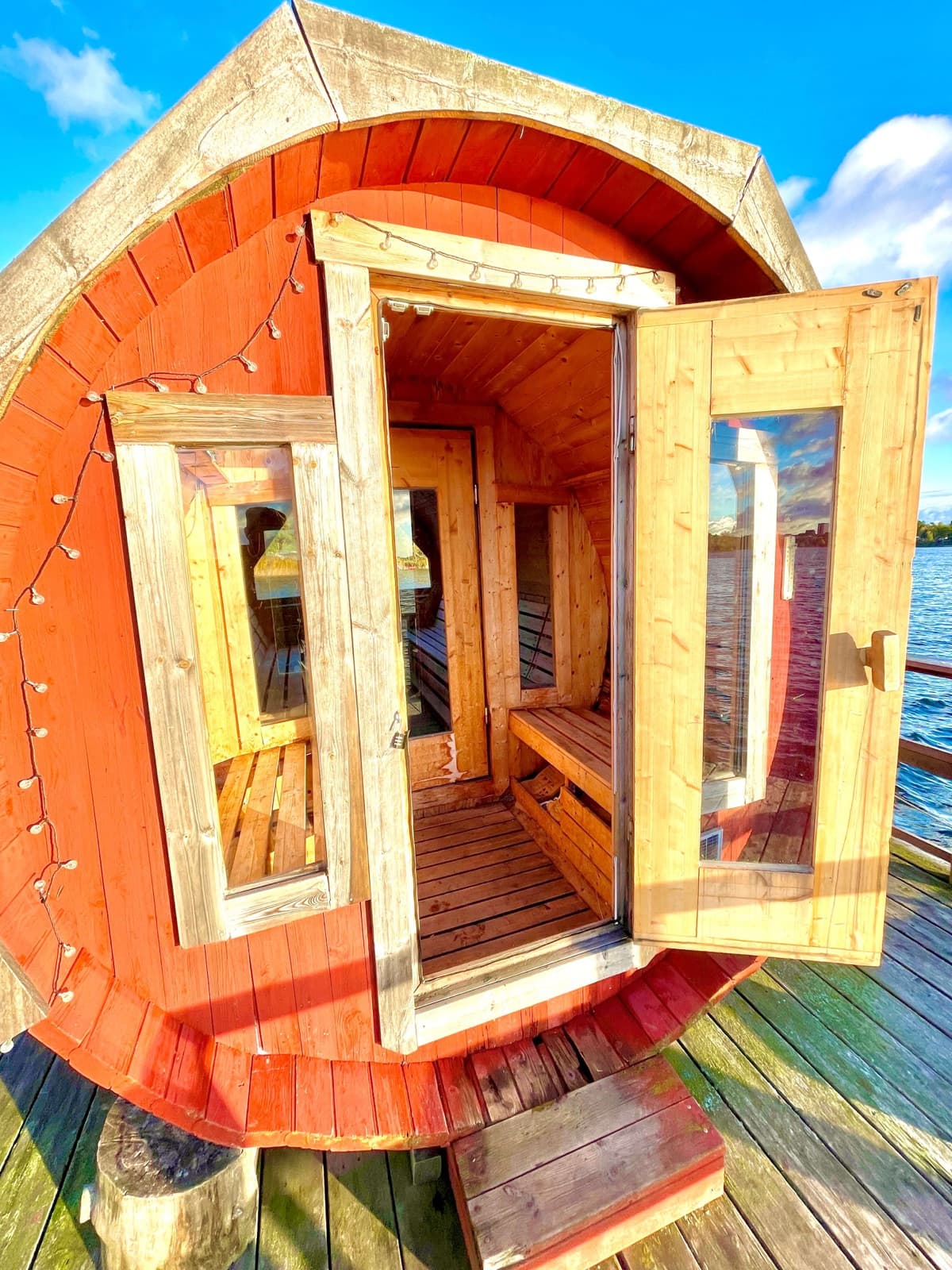 The sauna door open onto the raft deck and the lake on a sunny day