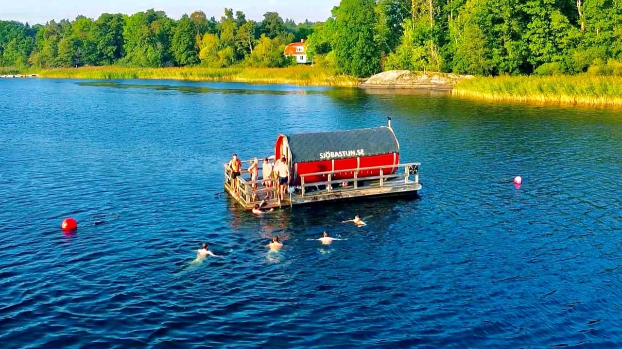 The sauna raft on Lake Drevviken with guests swimming around it