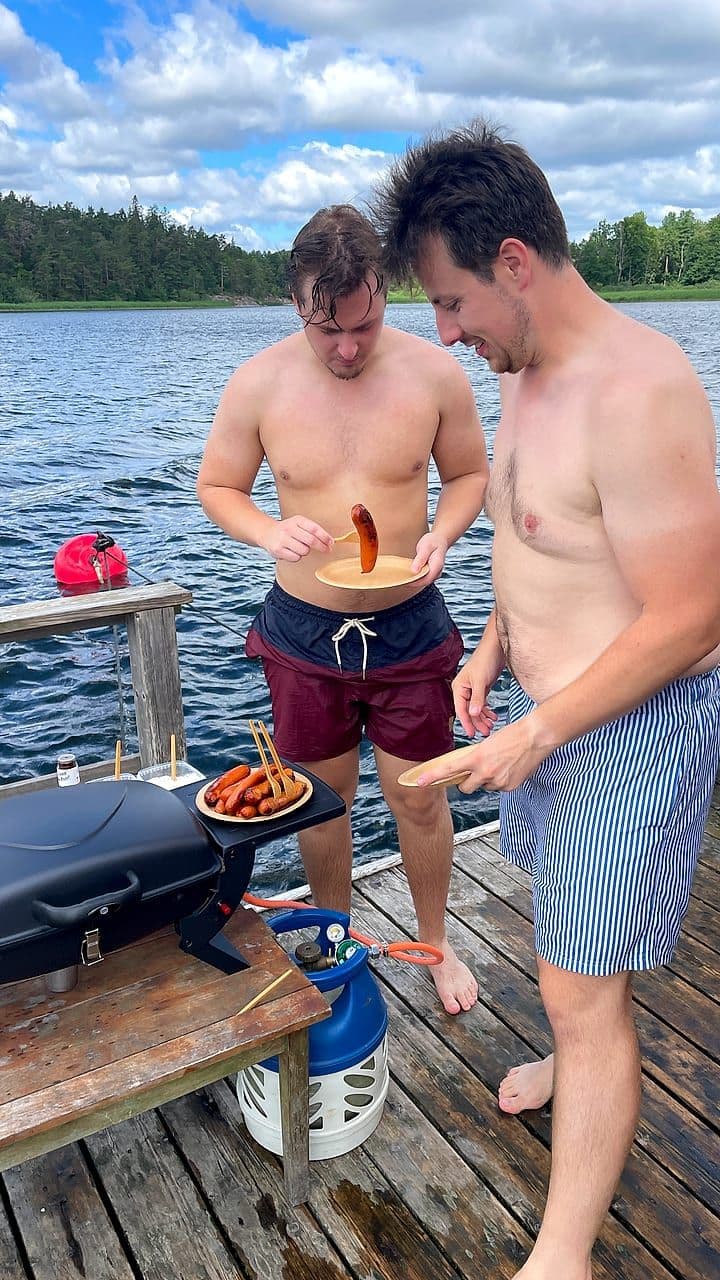 Två gäster grillar korv på flottens däck