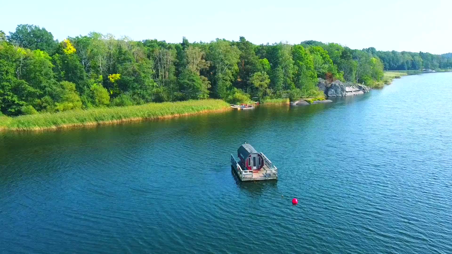 Sjöbastun vid Drevviken i skymning, ånga stiger från bastuflotten